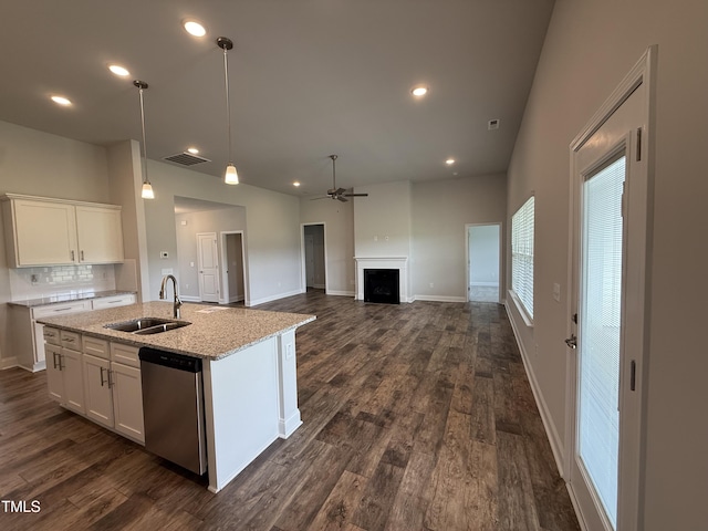 kitchen with stainless steel dishwasher, a sink, a ceiling fan, white cabinetry, and recessed lighting