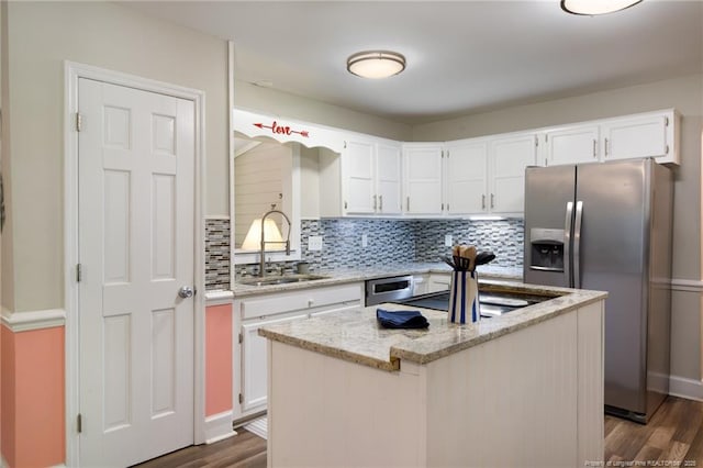kitchen featuring stainless steel refrigerator with ice dispenser, a sink, and white cabinetry