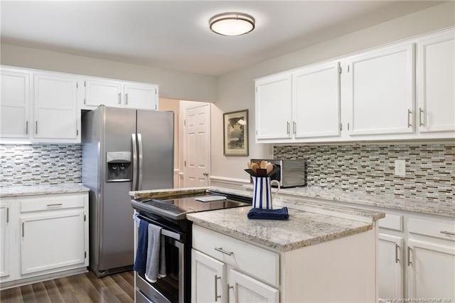 kitchen featuring appliances with stainless steel finishes, white cabinets, dark wood-type flooring, and light stone countertops