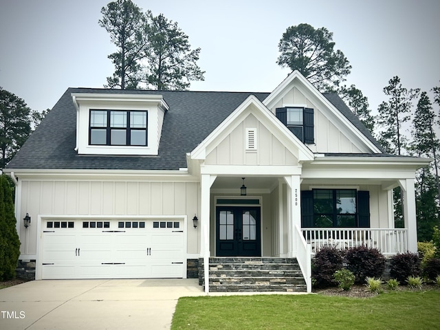 view of front of house featuring board and batten siding, concrete driveway, a porch, french doors, and a shingled roof