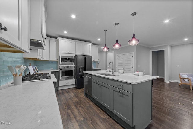 kitchen featuring appliances with stainless steel finishes, a sink, gray cabinetry, white cabinets, and backsplash