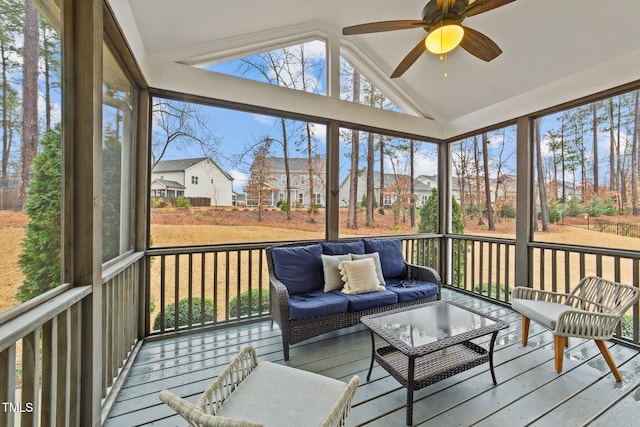 sunroom featuring lofted ceiling, ceiling fan, an outdoor living space, and a residential view