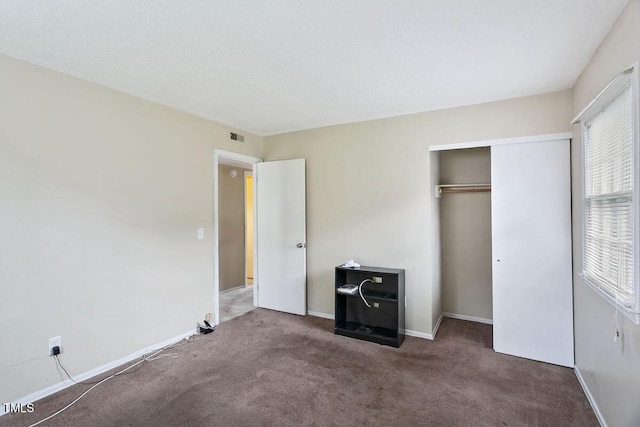 unfurnished bedroom with carpet floors, a closet, and baseboards