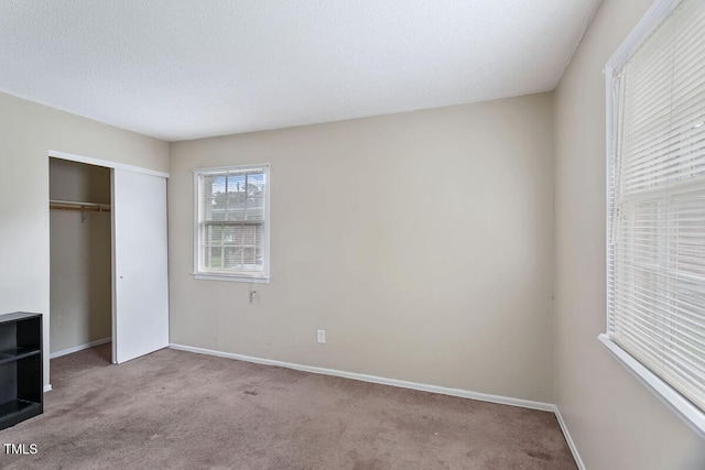 unfurnished bedroom featuring carpet flooring, baseboards, and a closet