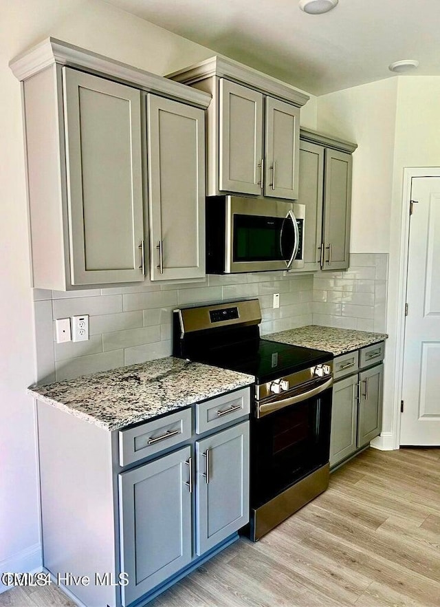 5134 Holly Hill Ct Lot 28, Battleboro, NC 27809 - kitchen featuring stainless steel appliances, gray cabinetry, light wood-style floors, and light stone countertops