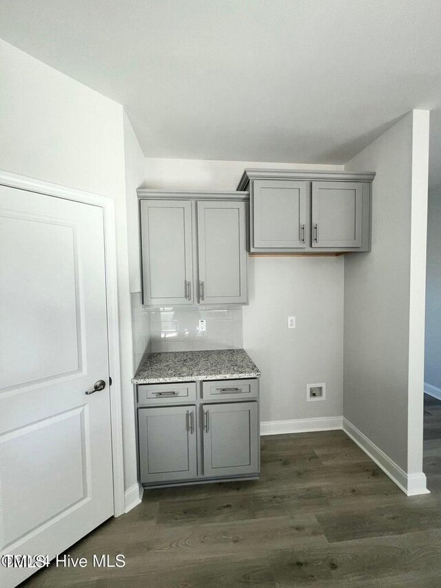 5134 Holly Hill Ct Lot 28, Battleboro, NC 27809 - kitchen with gray cabinetry, dark wood-type flooring, baseboards, and light stone counters