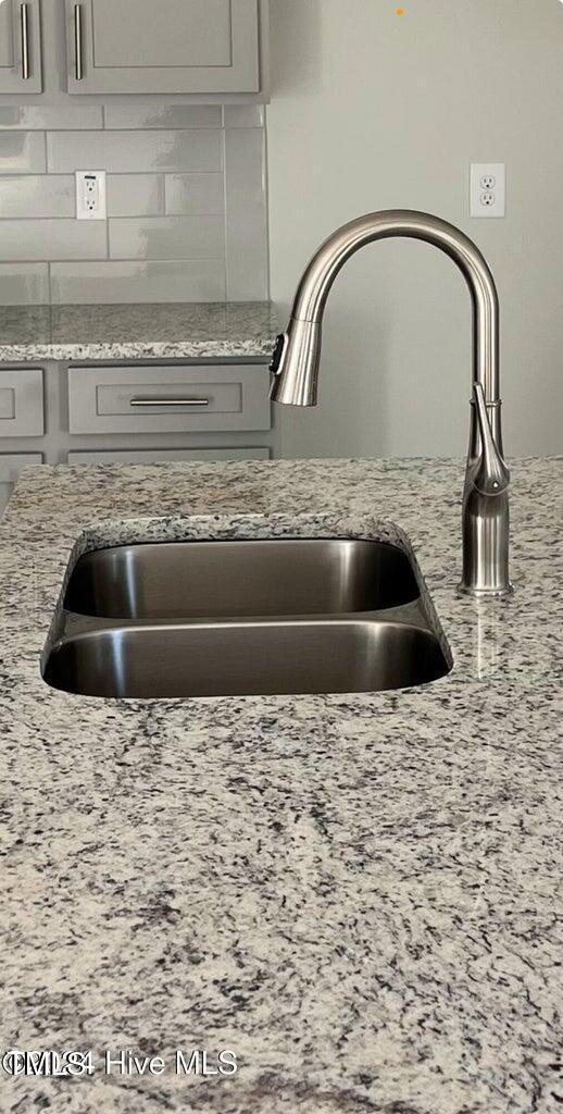 5134 Holly Hill Ct Lot 28, Battleboro, NC 27809 - kitchen view of a sink, tasteful backsplash, gray cabinets, and light stone counters