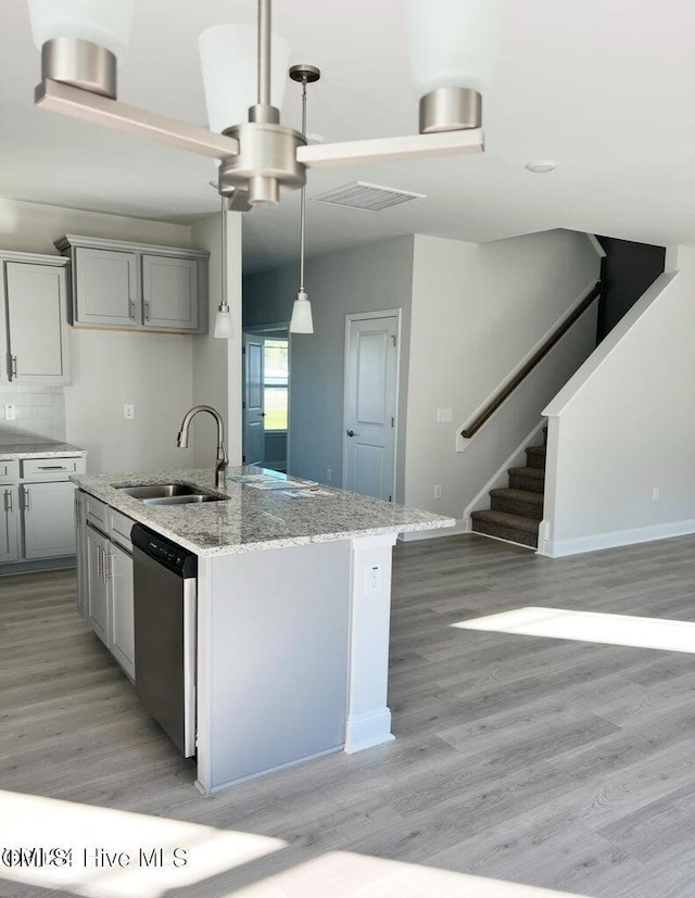 5134 Holly Hill Ct Lot 28, Battleboro, NC 27809 - kitchen featuring stainless steel dishwasher, a sink, light wood-style floors, light stone counters, and a kitchen island with sink