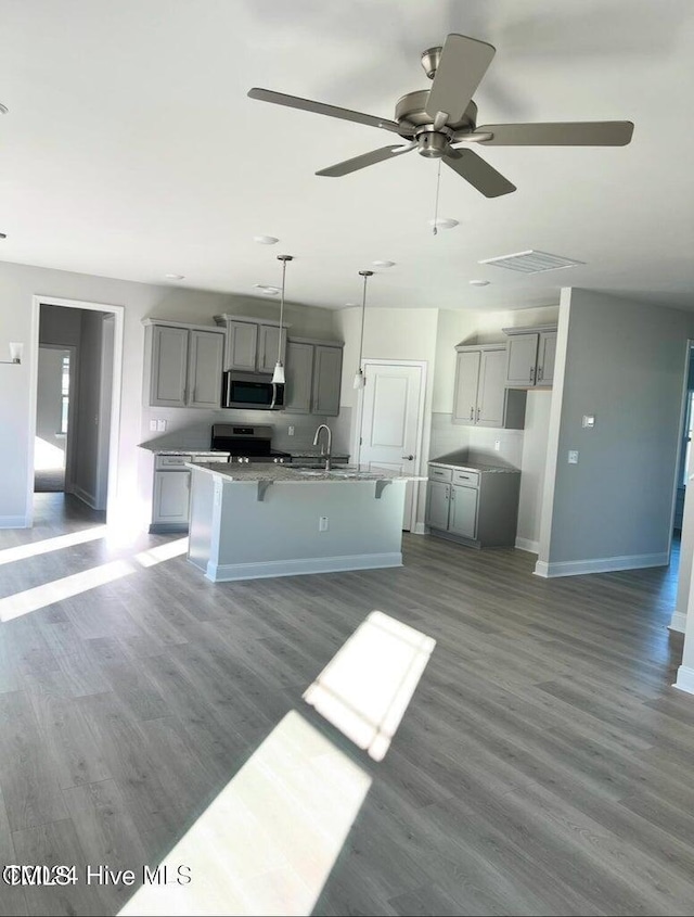 5134 Holly Hill Ct Lot 28, Battleboro, NC 27809 - kitchen featuring appliances with stainless steel finishes, gray cabinets, a sink, a kitchen island with sink, and baseboards