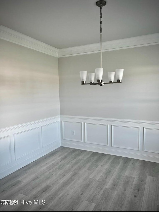 5134 Holly Hill Ct Lot 28, Battleboro, NC 27809 - unfurnished dining area featuring a decorative wall, light wood finished floors, crown molding, a chandelier, and a wainscoted wall