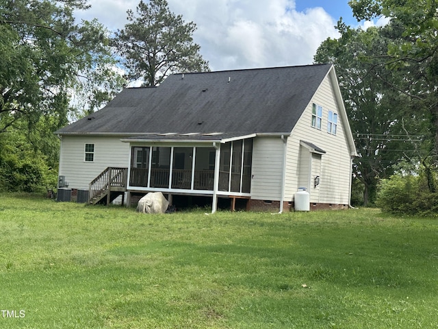 back of property with a sunroom, crawl space, a yard, and roof with shingles