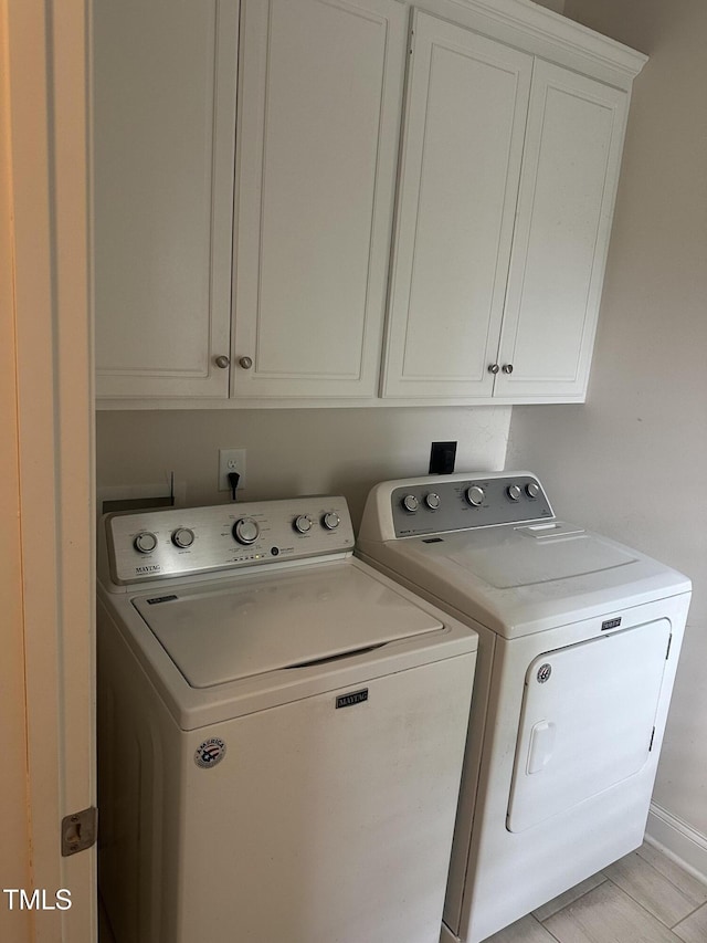 washroom with washing machine and dryer and cabinet space