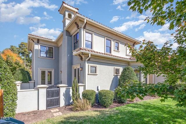 15 Treviso Pl, Durham, NC 27707 - back of property featuring a gate, stucco siding, and a tile roof