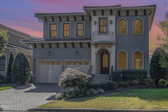 15 Treviso Pl, Durham, NC 27707 - view of front of house with a balcony, an attached garage, decorative driveway, stucco siding, and a front yard