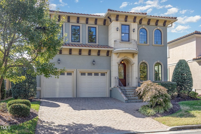 15 Treviso Pl, Durham, NC 27707 - mediterranean / spanish house featuring a balcony, an attached garage, driveway, stucco siding, and a tile roof
