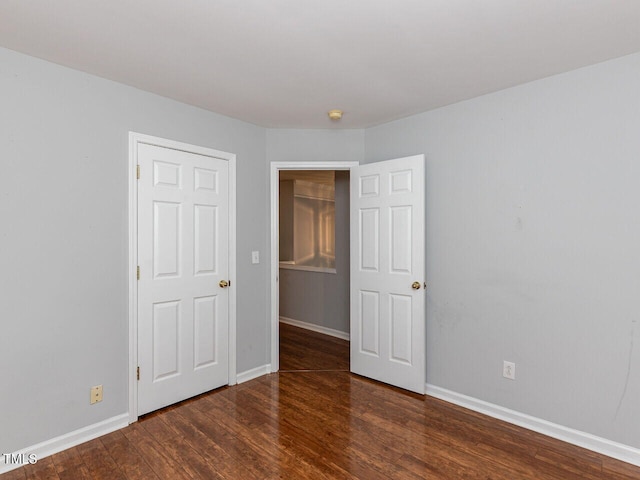 unfurnished bedroom featuring baseboards and wood finished floors