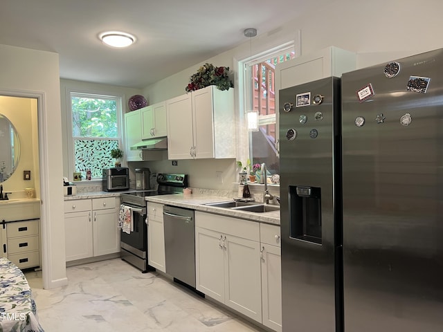 122 Button Rd, Morrisville, NC 27560 - kitchen featuring appliances with stainless steel finishes, under cabinet range hood, light marble finish floors, light countertops, and white cabinetry