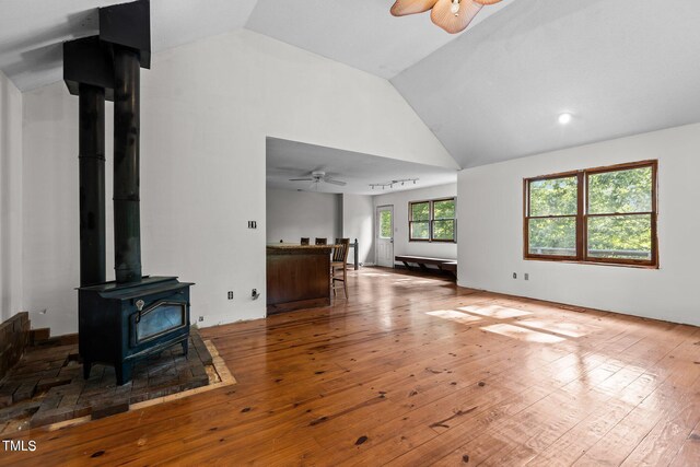 5900 Ebenezer Church Rd, Raleigh, NC 27612 - unfurnished living room with ceiling fan, hardwood / wood-style flooring, a wood stove, and high vaulted ceiling