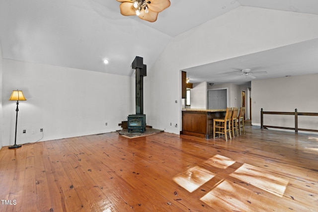 5900 Ebenezer Church Rd, Raleigh, NC 27612 - unfurnished living room with a ceiling fan, vaulted ceiling, a wood stove, and wood-type flooring