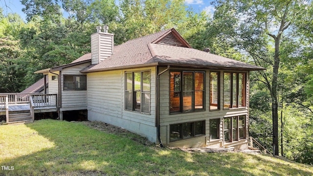 5900 Ebenezer Church Rd, Raleigh, NC 27612 - view of side of property featuring a chimney, a sunroom, roof with shingles, a deck, and a lawn