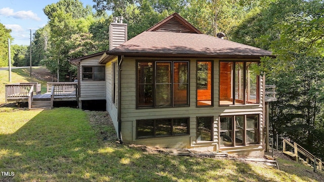 5900 Ebenezer Church Rd, Raleigh, NC 27612 - back of property with a chimney, a shingled roof, a wooden deck, and a yard