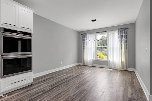 1003 E Sterlington Pl, Apex, NC 27502 - unfurnished living room featuring dark wood-style flooring and baseboards