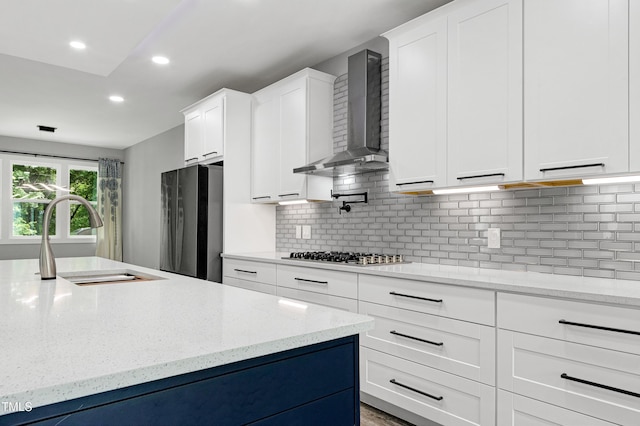 1003 E Sterlington Pl, Apex, NC 27502 - kitchen with wall chimney exhaust hood, stainless steel appliances, a sink, white cabinets, and tasteful backsplash