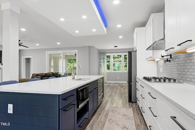 1003 E Sterlington Pl, Apex, NC 27502 - kitchen with appliances with stainless steel finishes, a sink, white cabinets, light wood-style floors, and light countertops
