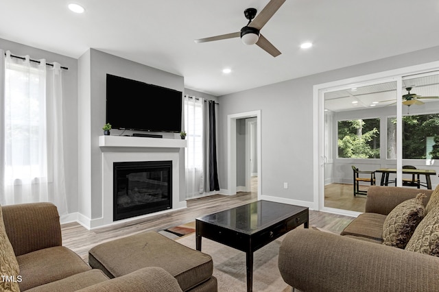1003 E Sterlington Pl, Apex, NC 27502 - living area featuring ceiling fan, light wood finished floors, a glass covered fireplace, baseboards, and recessed lighting