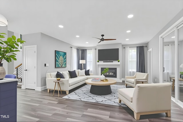 1003 E Sterlington Pl, Apex, NC 27502 - living room featuring ceiling fan, wood finished floors, a glass covered fireplace, recessed lighting, and stairway