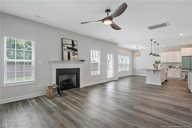 633 Amusement Dr, Hope Mills, NC 28348 - unfurnished living room featuring plenty of natural light, dark wood-style flooring, a fireplace, a ceiling fan, and recessed lighting