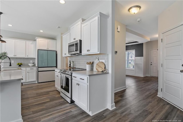 633 Amusement Dr, Hope Mills, NC 28348 - kitchen with appliances with stainless steel finishes, dark wood-style floors, white cabinetry, recessed lighting, and decorative backsplash