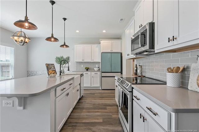 633 Amusement Dr, Hope Mills, NC 28348 - kitchen with appliances with stainless steel finishes, white cabinets, light countertops, dark wood-type flooring, and recessed lighting