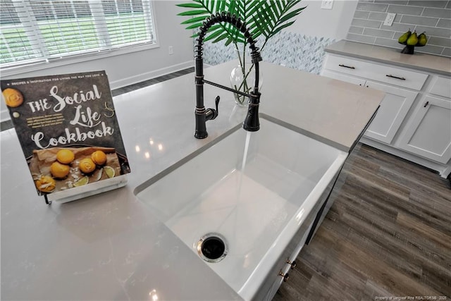 633 Amusement Dr, Hope Mills, NC 28348 - kitchen view of tasteful backsplash, dark wood-style floors, white cabinetry, a sink, and light countertops