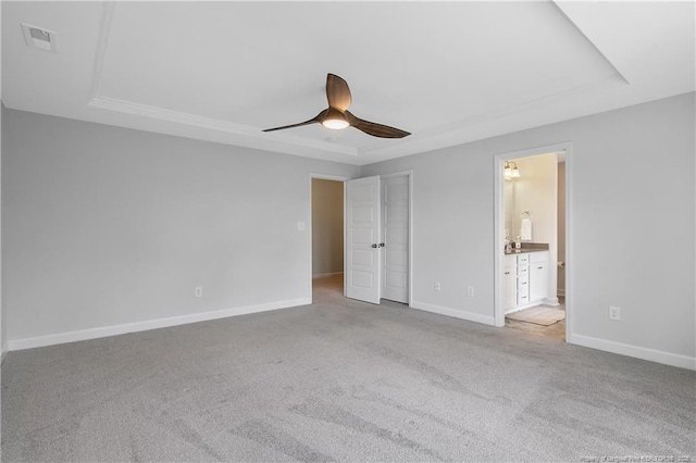 633 Amusement Dr, Hope Mills, NC 28348 - unfurnished bedroom with a tray ceiling, carpet flooring, and baseboards