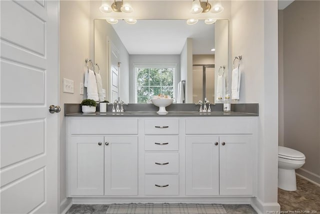 633 Amusement Dr, Hope Mills, NC 28348 - full bath featuring double vanity, toilet, baseboards, and a shower with shower door