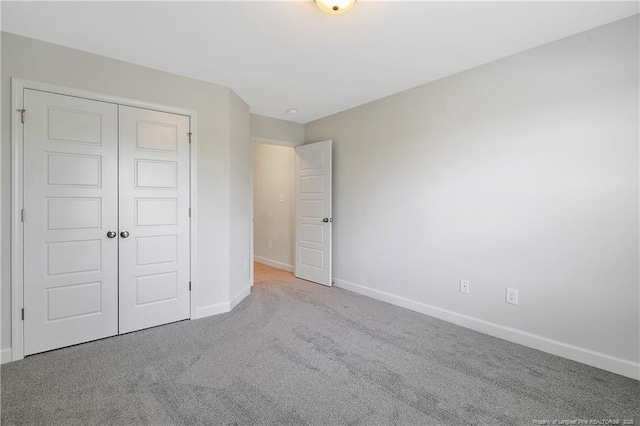 633 Amusement Dr, Hope Mills, NC 28348 - unfurnished bedroom with baseboards, carpet, and a closet