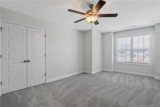 633 Amusement Dr, Hope Mills, NC 28348 - unfurnished bedroom with carpet flooring, baseboards, a ceiling fan, and a closet
