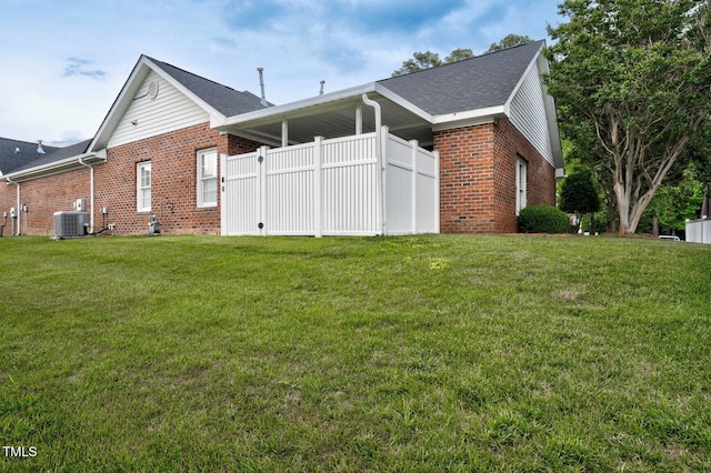 106 Irene Ct, Rocky Mount, NC 27804 - view of home's exterior with brick siding, cooling unit, a yard, and roof with shingles