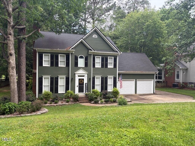 colonial home with an attached garage, concrete driveway, a front lawn, and a shingled roof