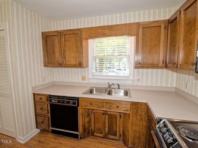119 Long Shadow Ln, Cary, NC 27518 - kitchen with black dishwasher, wallpapered walls, a sink, wood finished floors, and light countertops