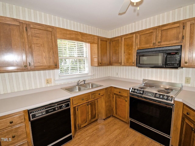 119 Long Shadow Ln, Cary, NC 27518 - kitchen featuring black appliances, wallpapered walls, a sink, light countertops, and brown cabinetry