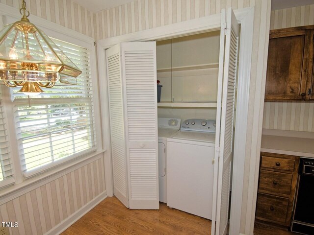 119 Long Shadow Ln, Cary, NC 27518 - laundry room featuring wallpapered walls, washing machine and clothes dryer, a chandelier, and light wood-type flooring