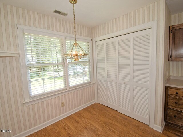 119 Long Shadow Ln, Cary, NC 27518 - unfurnished dining area with wallpapered walls, light wood-type flooring, a chandelier, and baseboards