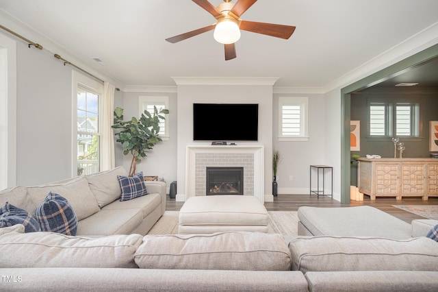 living room with ornamental molding, wood finished floors, plenty of natural light, and a ceiling fan