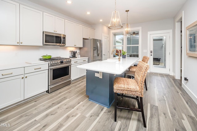 kitchen featuring appliances with stainless steel finishes, light wood-style flooring, tasteful backsplash, a sink, and recessed lighting