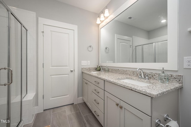 full bath with a shower stall and double vanity
