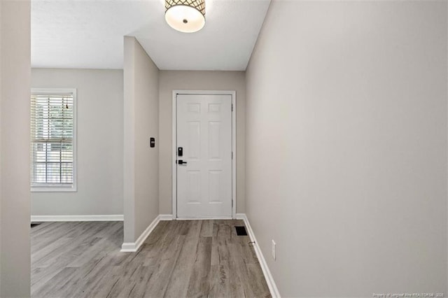 doorway to outside featuring wood finished floors and baseboards