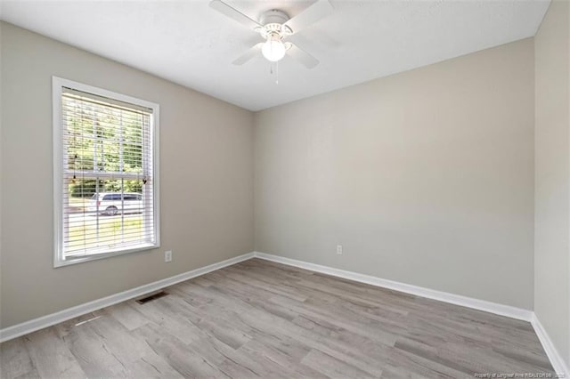 unfurnished room with wood finished floors, a ceiling fan, and baseboards
