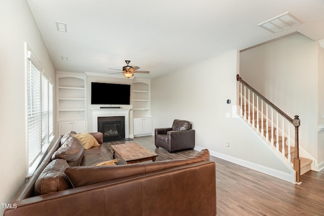 111 Laporte Path, Garner, NC 27529 - living room featuring ceiling fan, a fireplace with flush hearth, stairs, and wood finished floors